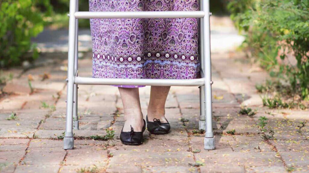 Donna anziana che cammina con il deambulatore