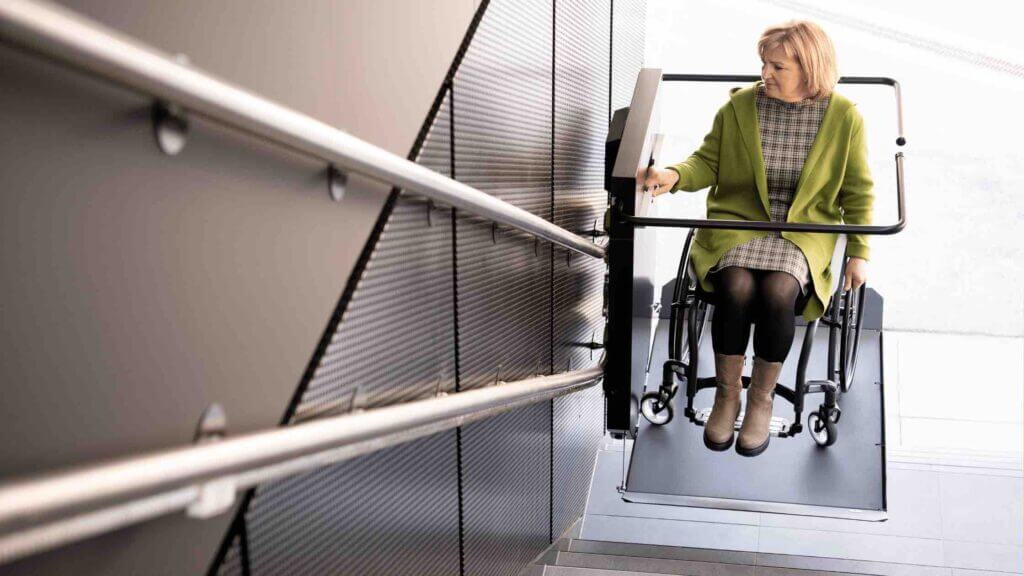 Signora anziana utilizza piattaforma saliscale in condominio