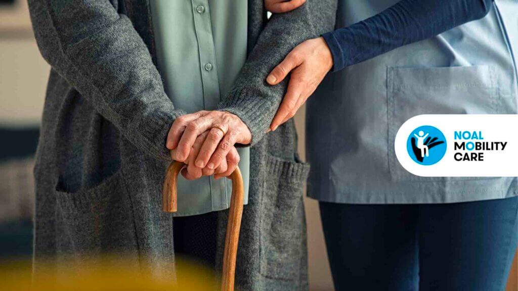 Anziana con bastone e assistente