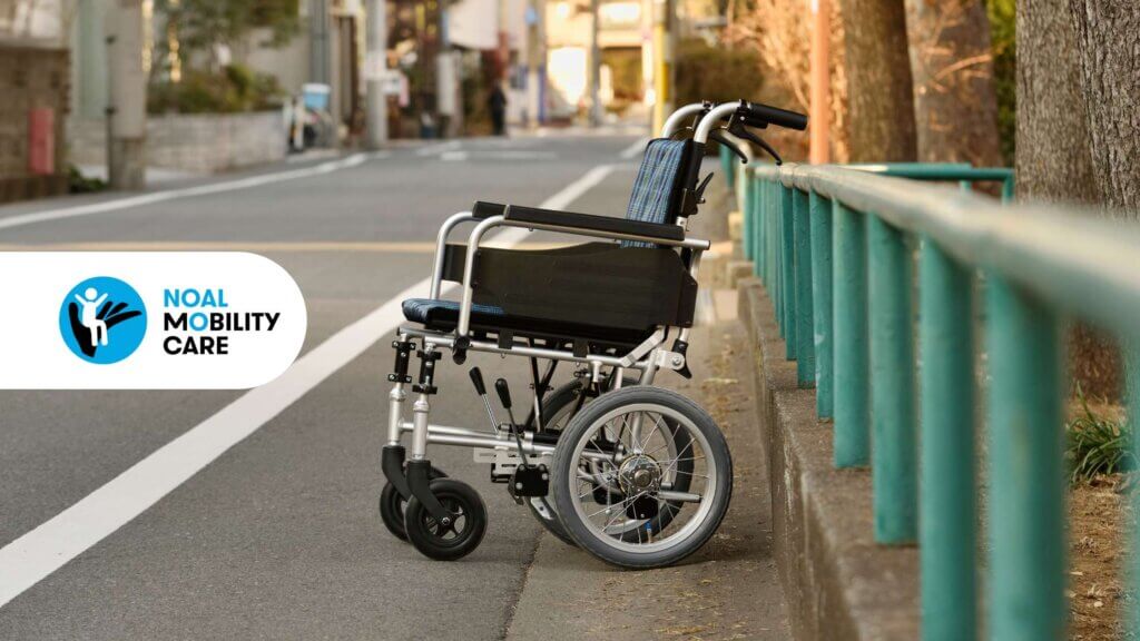 Una sedia a rotelle vuota a fianco di una strada