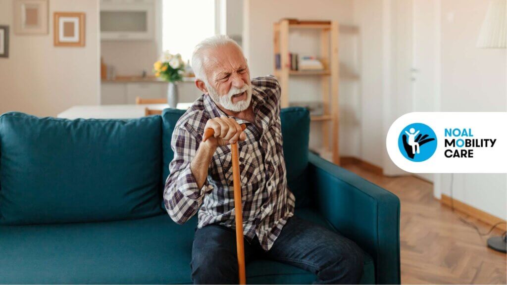 Un anziano seduto sul divano che ha dolore alla schiena