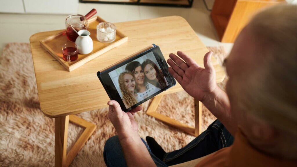 Anziano che non può muoversi parla in videochiamata con i suoi cari a Natale