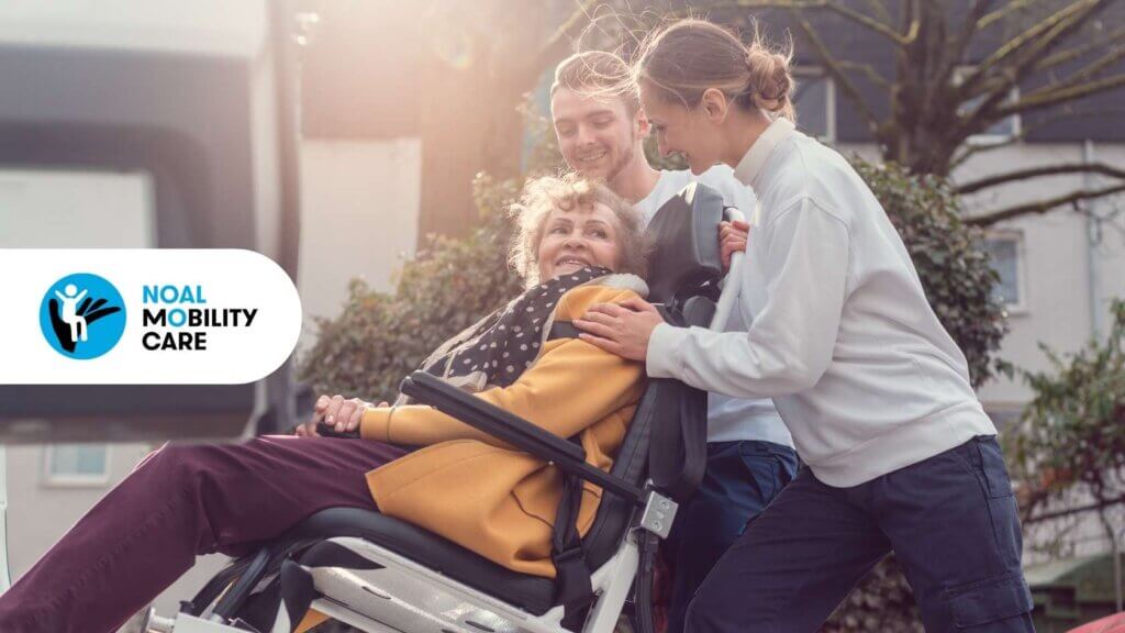Due giovani ragazzi trasportano una persona anziana con disabilità su scale