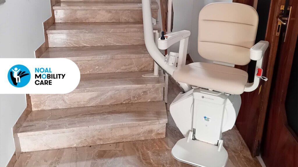 Montascale a poltroncina installato in scala condominiale per migliorare l’accessibilità e abbattere le barriere architettoniche.