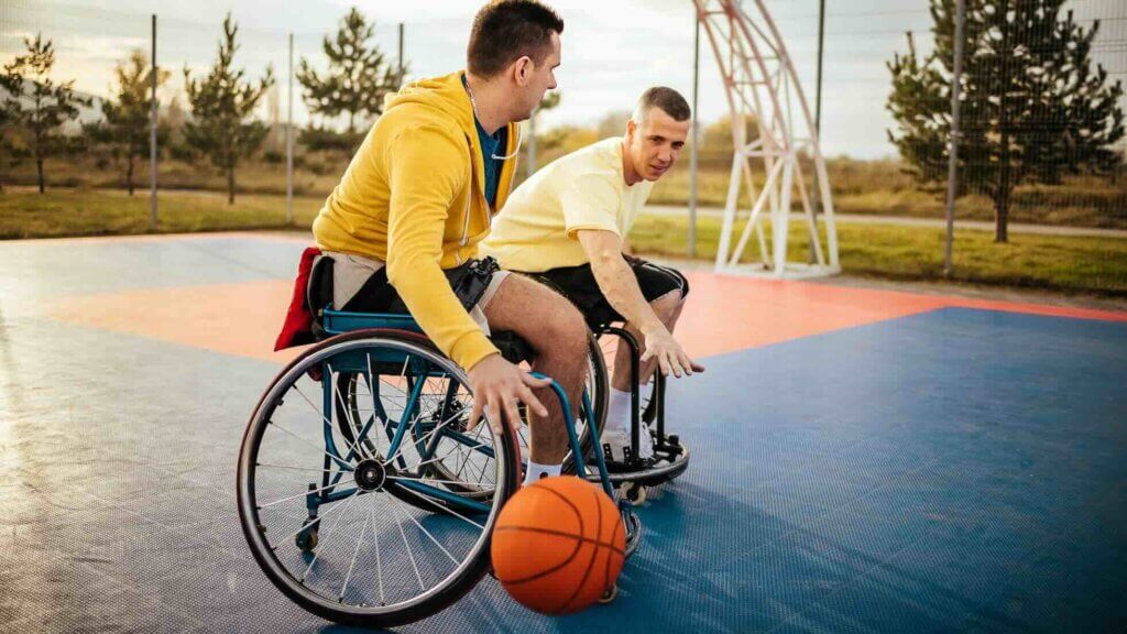 Due uomini in carrozzina giocano a pallacanestro
